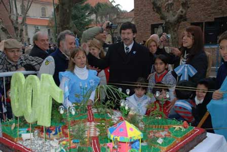 El intendente Gustavo Posse y vecinos junto a la inmensa torta con la forma de la centenaria plaza 9 de Julio El intendente Gustavo Posse y vecinos junto a la inmensa torta con la forma de la centenaria plaza 9 de Julio