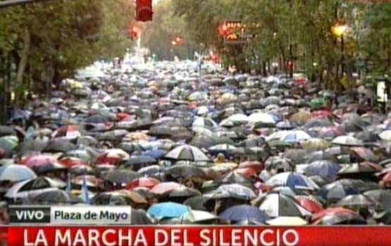 Miles de personas se concentran bajo una intensa lluvia, reflejando una alfombra de paraguas, en marcha por Nisman